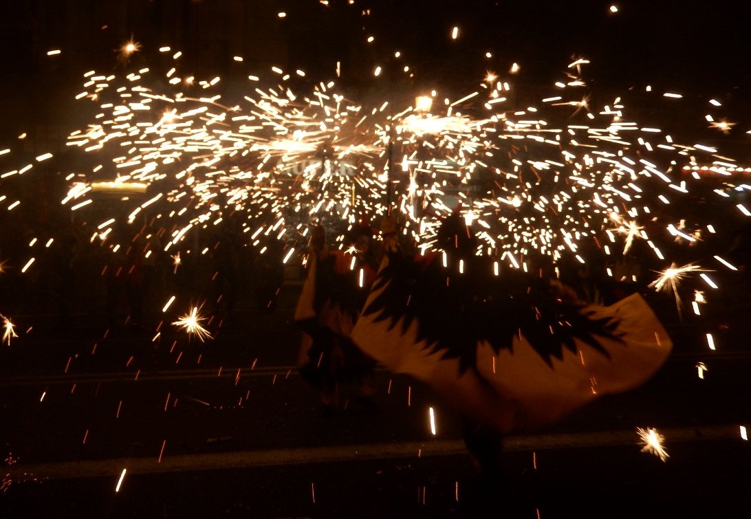 Vuurspuwende duivels trekken tijdens een correfoc door een straat in Barcelona
