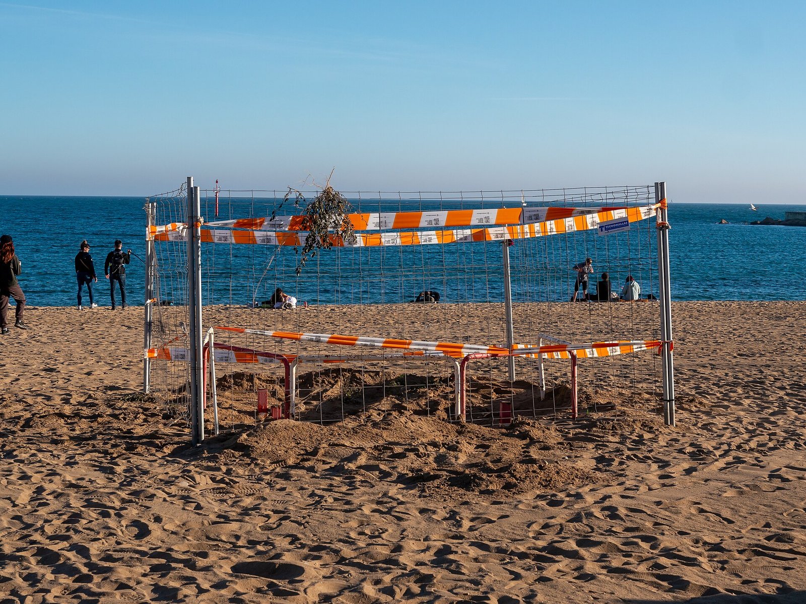 Zandstrand van Barceloneta met zonnende bezoekers en de boulevard erachter