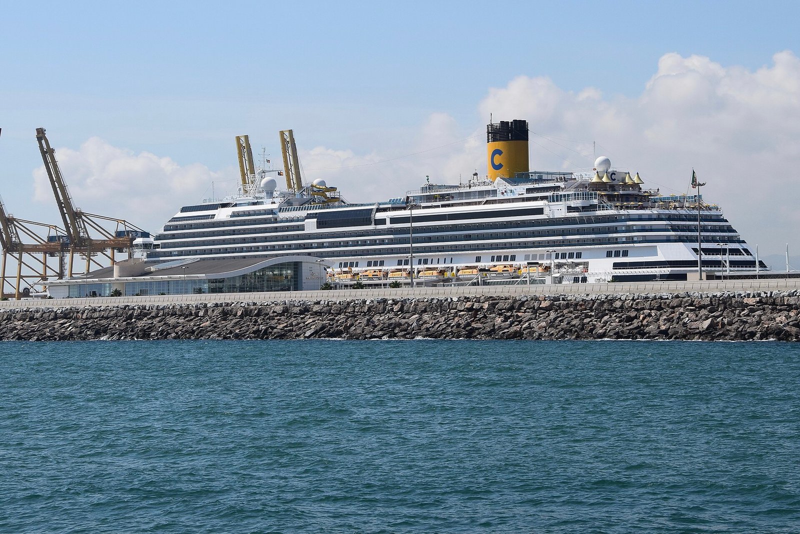 Cruiseschip afgemeerd in de haven van Barcelona met de stad erachter